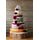 7 tier cheese and pork pie cake, the base of the cake is the pork pie and the rest is cheese. This cake has decorative red flowers and ribbons. The top cheese is heart shaped.