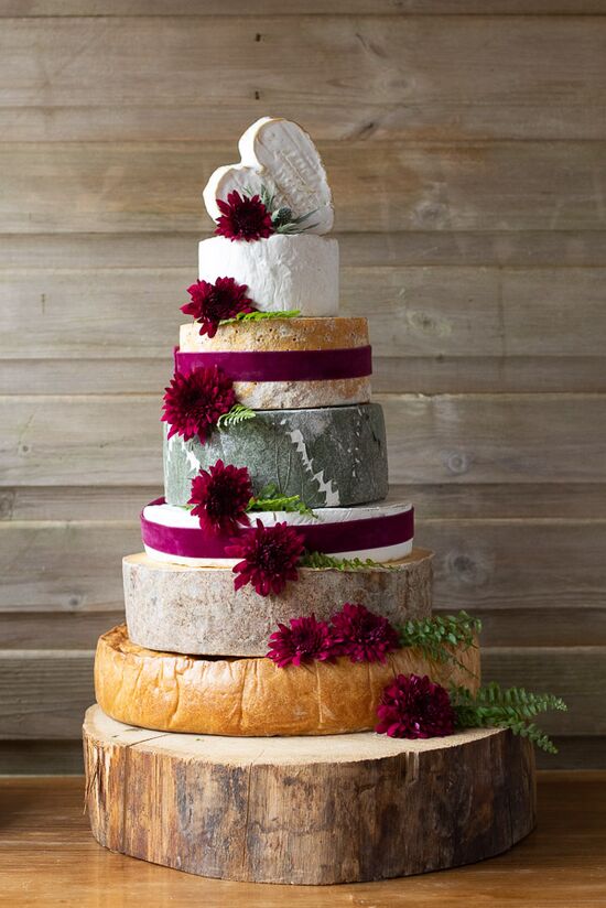 7 tier cheese and pork pie cake, the base of the cake is the pork pie and the rest is cheese. This cake has decorative red flowers and ribbons. The top cheese is heart shaped.