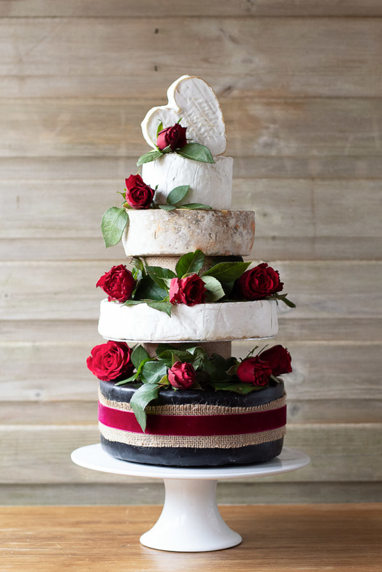 This absolutely stunning Cheese Cake has 5 tiers, one of which is heart shaped and at the top of the cake. This cake is decorated with gorgeous red roses and greenery.