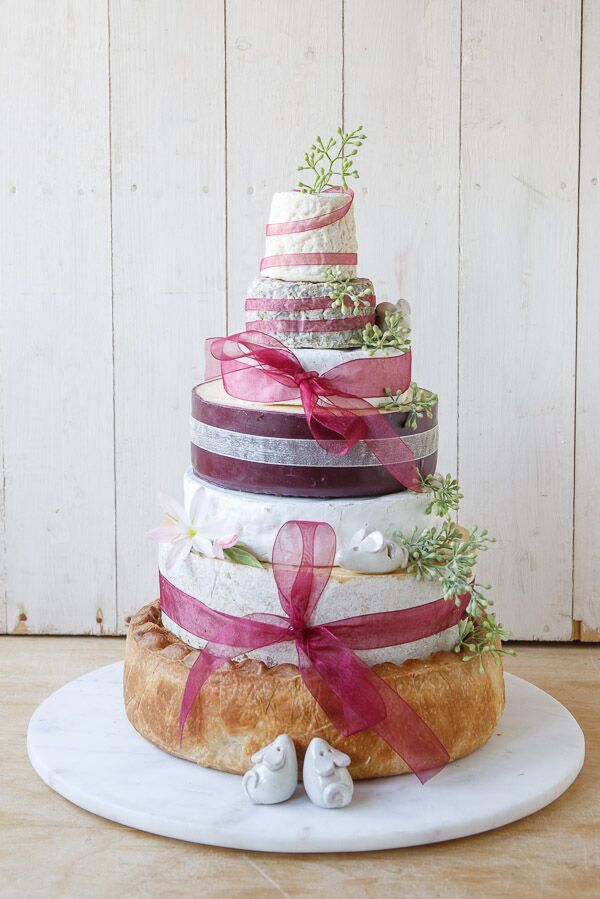 Pork Pie and Cheddar Cheese cake with large pork pie at base and 6 tiers of different cheese, decorated with burgundy organza ribbon and white glazed mice