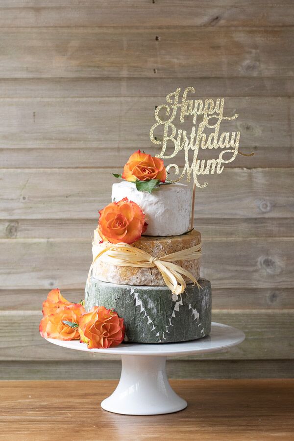 Adorable 3 tier celebration cheese cake with decorative orange flowers, perfect for a birthday.