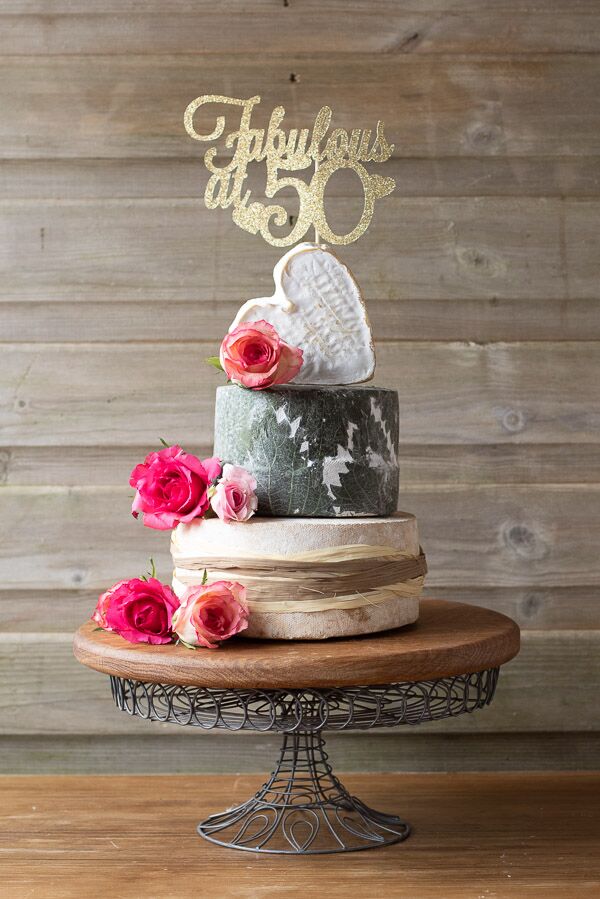 Our 3 tier charming cheese cake is perfect for a special occasion. the tiers include, heart shaped Coeur's Neufchatel, Yarg and Cheddar. Decorated with pink roses and natural raffia.